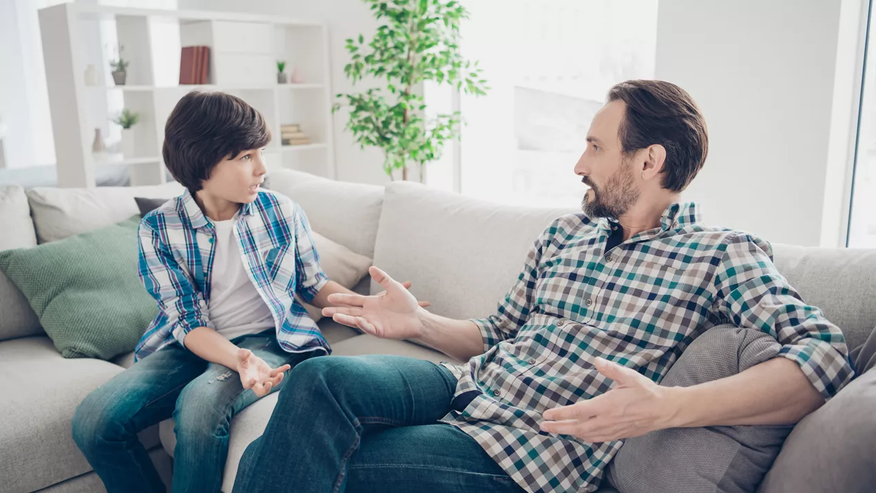 Support worker sitting next to young person in residential care home