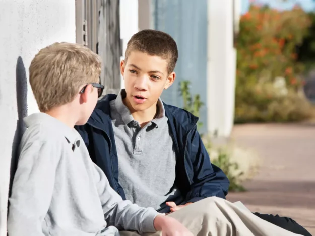 Two young people sat outside talking