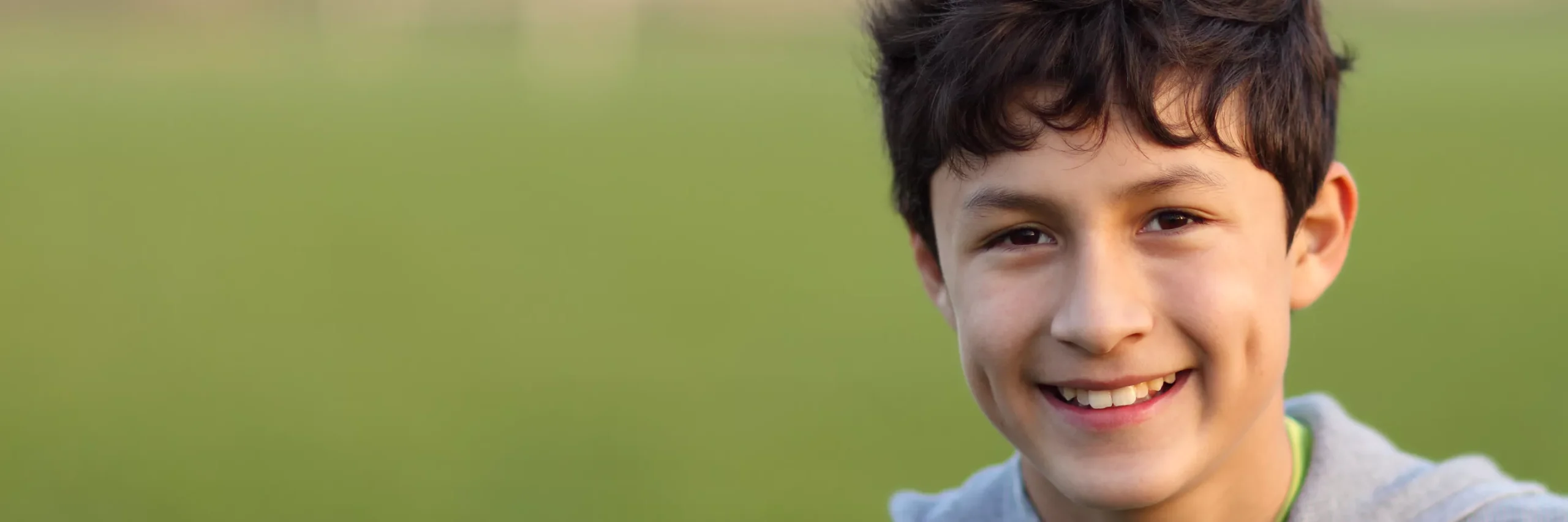 Young boy smiling whilst out in a field