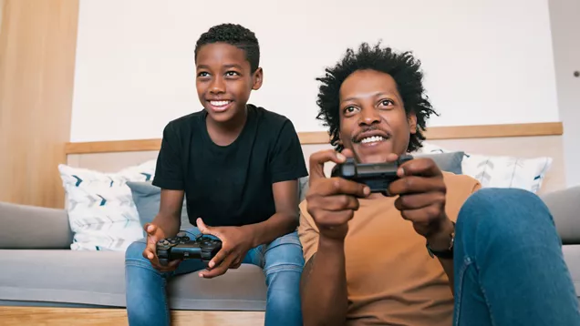 Young person and support worker playing on a games console