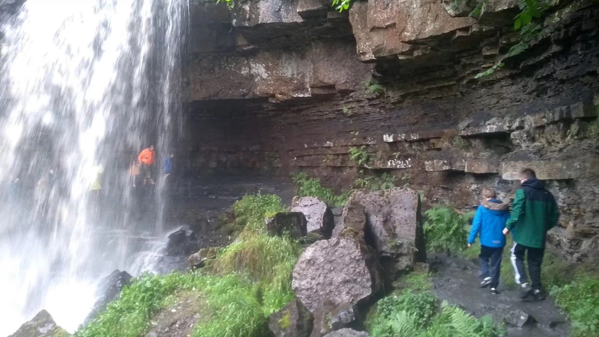 Young people hiking by a waterfall