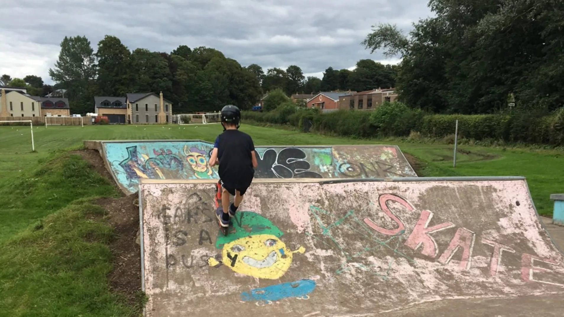 Young person on a scooter at a local skate park