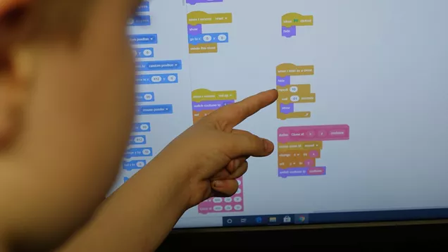 Kirby Moor school pupil points at their coding work