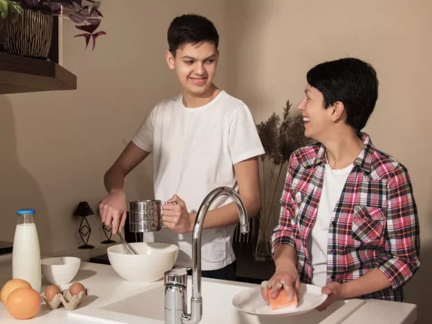 Support worker helping young person in the kitchen